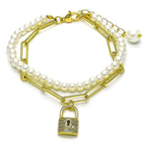 Chic double-strand bracelet combining faux pearls and gold paperclip chain, finished with a sparkling gold padlock charm for a trendy layered look.