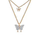 Layered gold necklace featuring two butterfly pendants—one small and gold, the other larger and encrusted with shimmering pavé crystals—for a feminine and whimsical touch.
