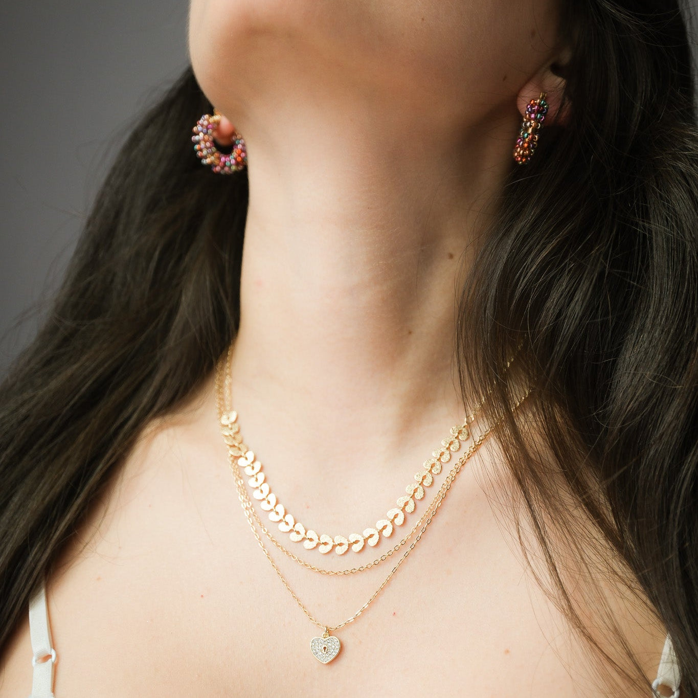 Woman wearing layered gold necklaces in different lengths