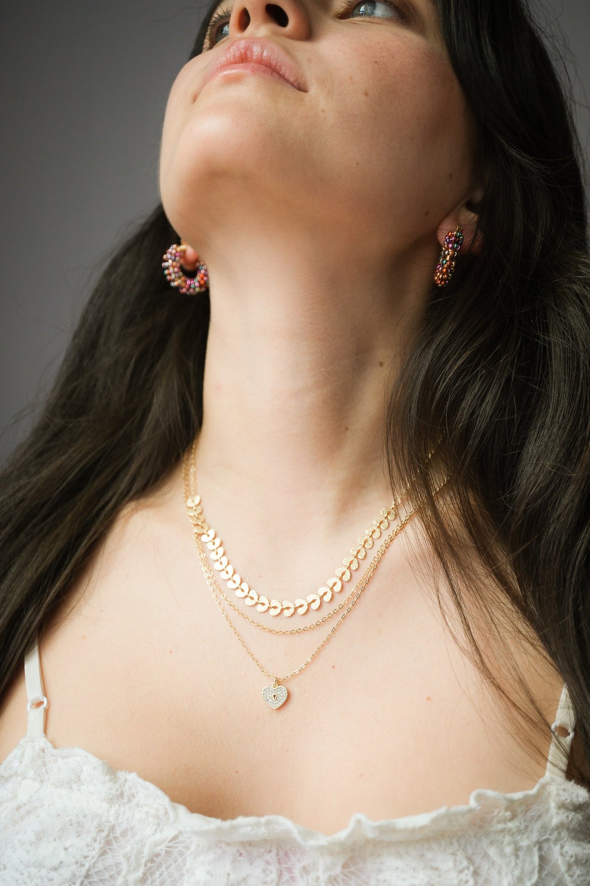 Woman wearing layered gold necklaces in different lengths